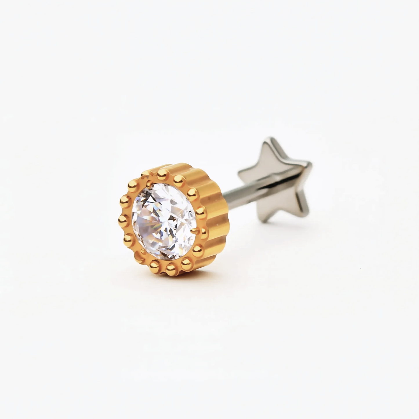 Angled front view of the Titanium Crown Spark internally threaded flat back stud earring with a gold finish and round crystal center in a crown-style setting. Hypoallergenic and safe for sensitive ears.