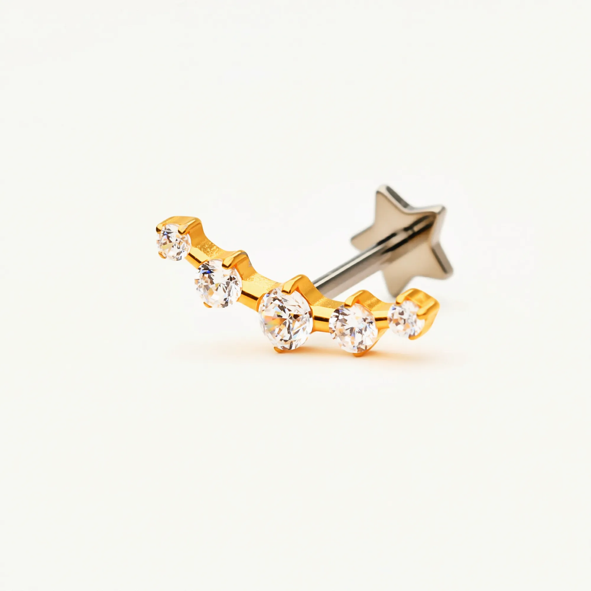 Angled front view of the Titanium Radiant Row internally threaded flat back stud earring with a gold finish, showcasing the star accent and sparkling crystal row.