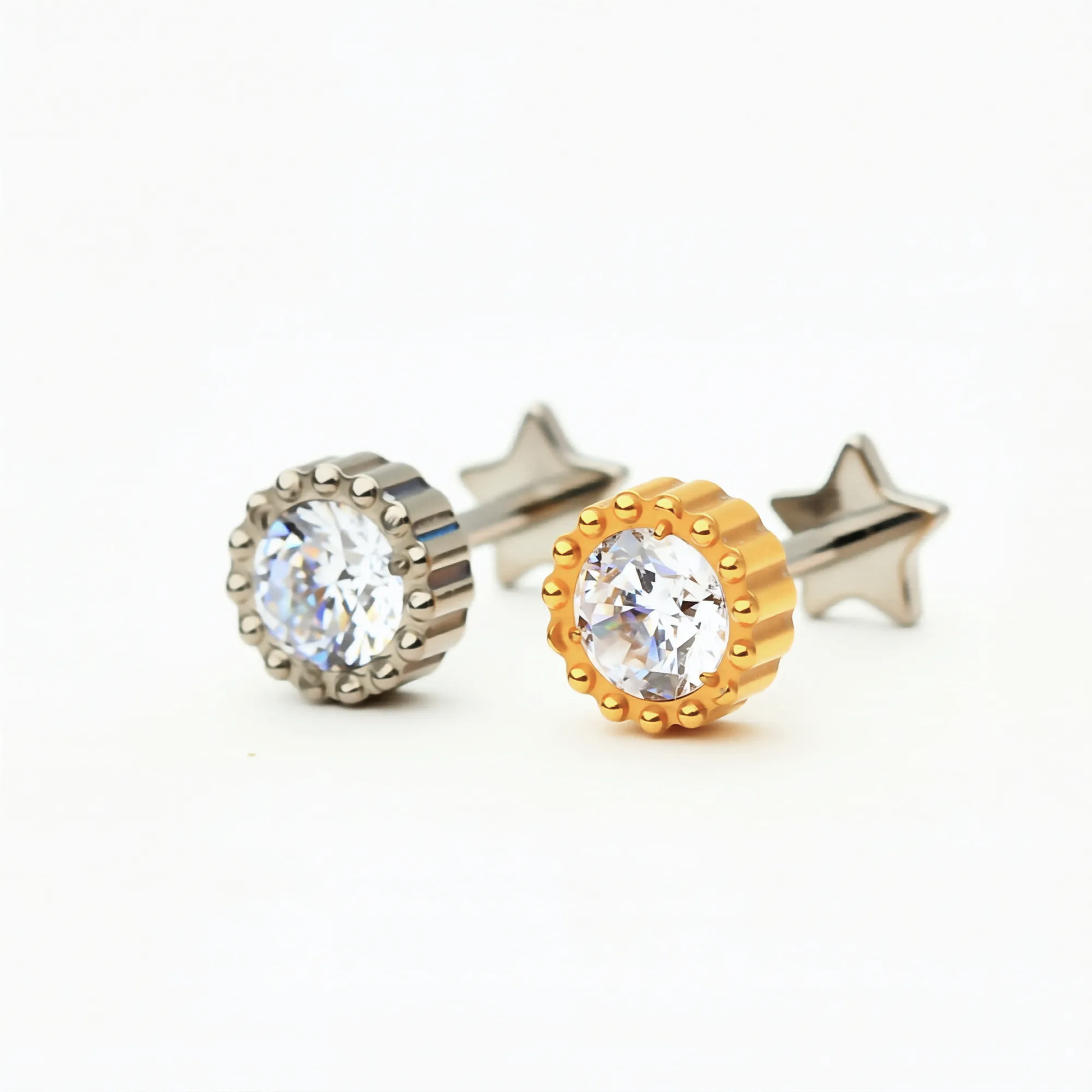 Titanium Crown Spark internally threaded flat back stud earrings in natural titanium and gold, featuring a round crystal center with a crown-style setting. Front view of hypoallergenic implant-grade titanium studs.