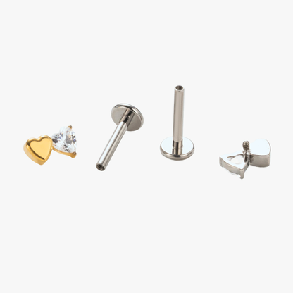 Disassembled view of the Titanium Duo Heart internally threaded flat back stud earring, showing the gold and natural titanium heart-shaped tops, implant-grade titanium post, visible internal threading, and smooth flat back base.