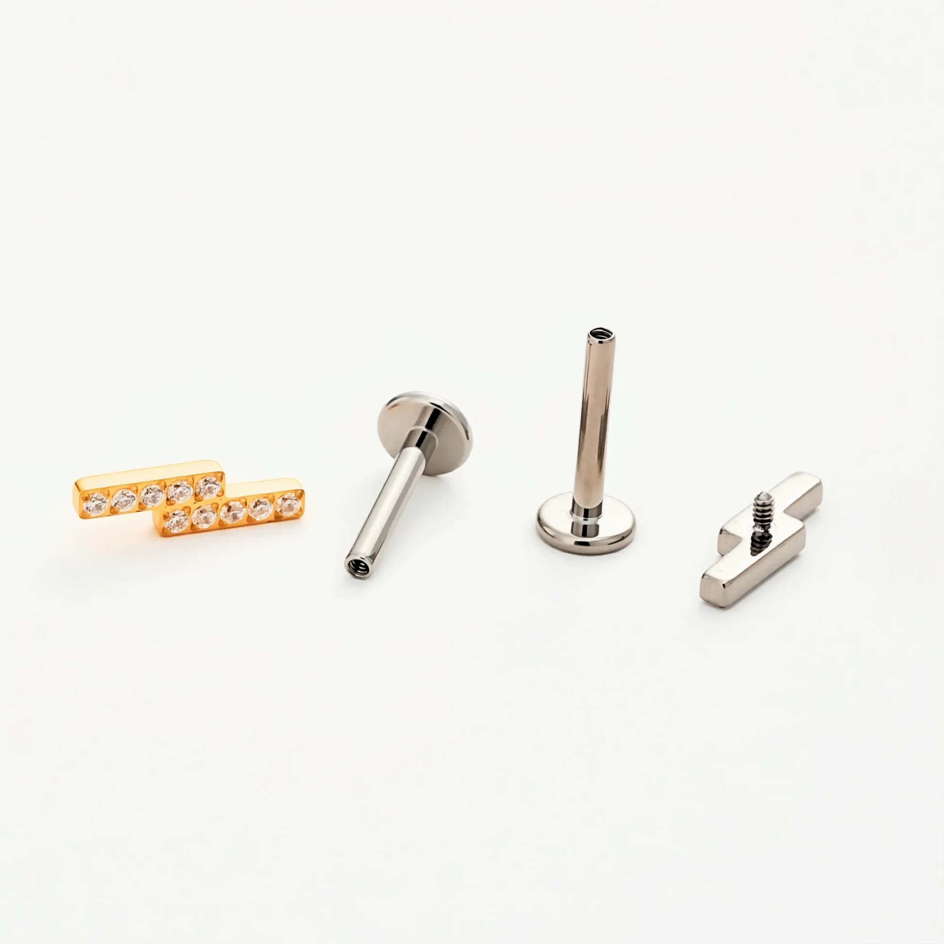 Disassembled view of the Titanium Twin Bar internally threaded flat back stud earring, showing the gold and natural titanium bar tops, implant-grade titanium post with internal threading, and smooth flat back base.