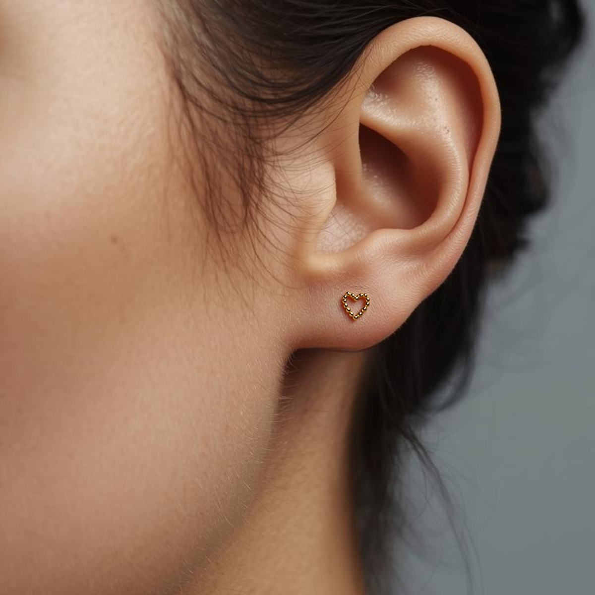 Beaded Heart gold-plated titanium earring worn on the earlobe