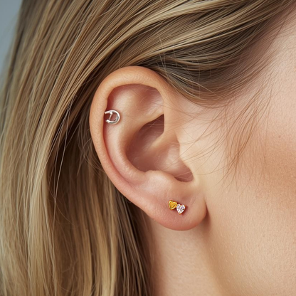 Model wearing the Titanium Duo Heart internally threaded flat back stud earring in natural titanium, showing the double-heart design and comfortable flat back fit.