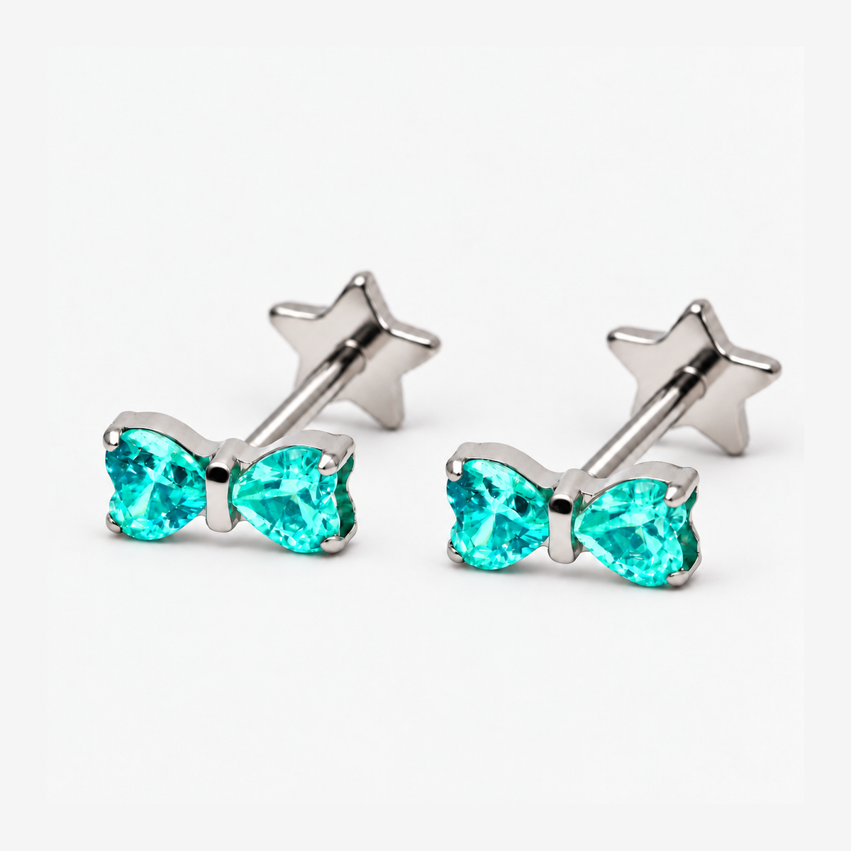 Two Heart Bow titanium flat back earrings with teal heart-shaped cubic zirconia stones, supplementary view; earrings sold individually