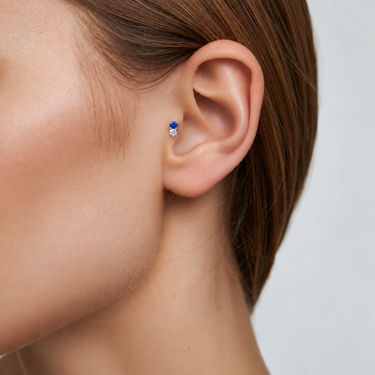 Moonlit blue and clear CZ titanium earring worn on the tragus