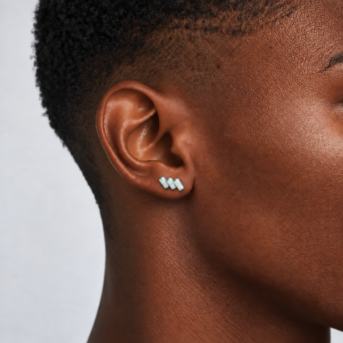 Opal Steps titanium earring with three rectangular opals, worn on the earlobe