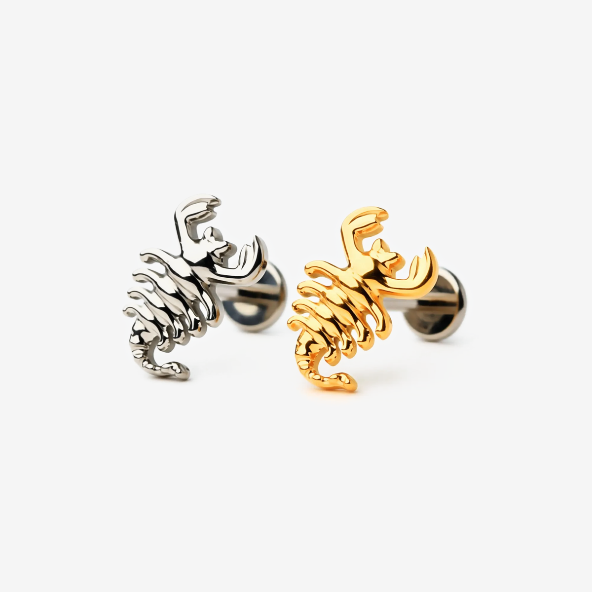 Scorpion Curve flat back stud earrings in titanium and gold.