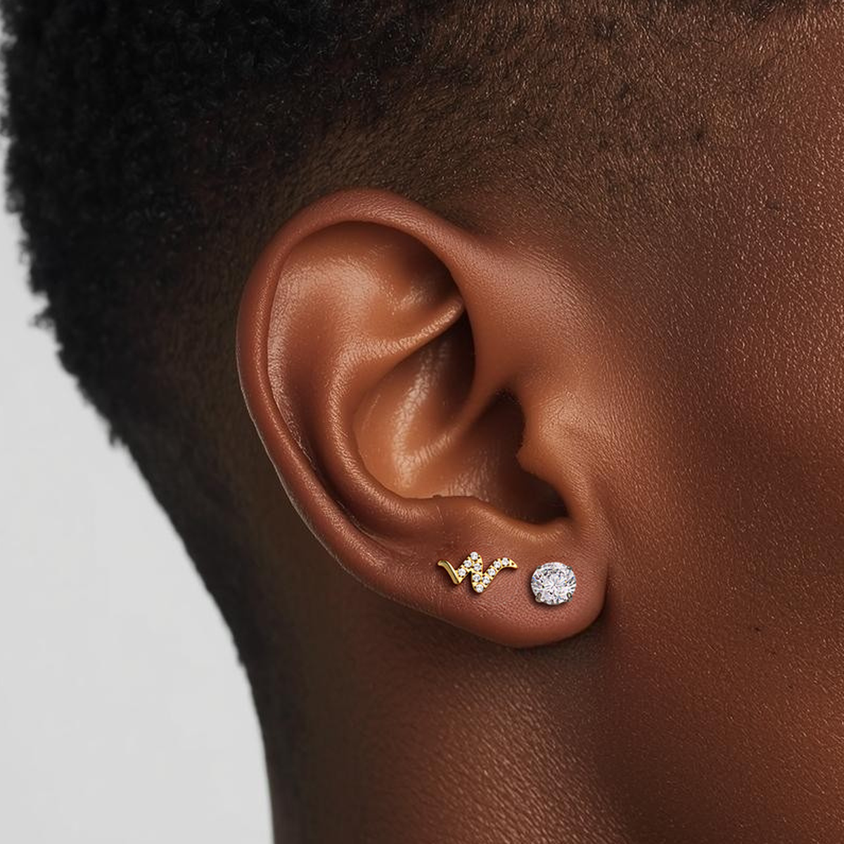 Model wearing the Titanium Snaked Wave internally threaded flat back stud earring in natural titanium, showing the crystal-lined wave design and comfortable flat back fit.