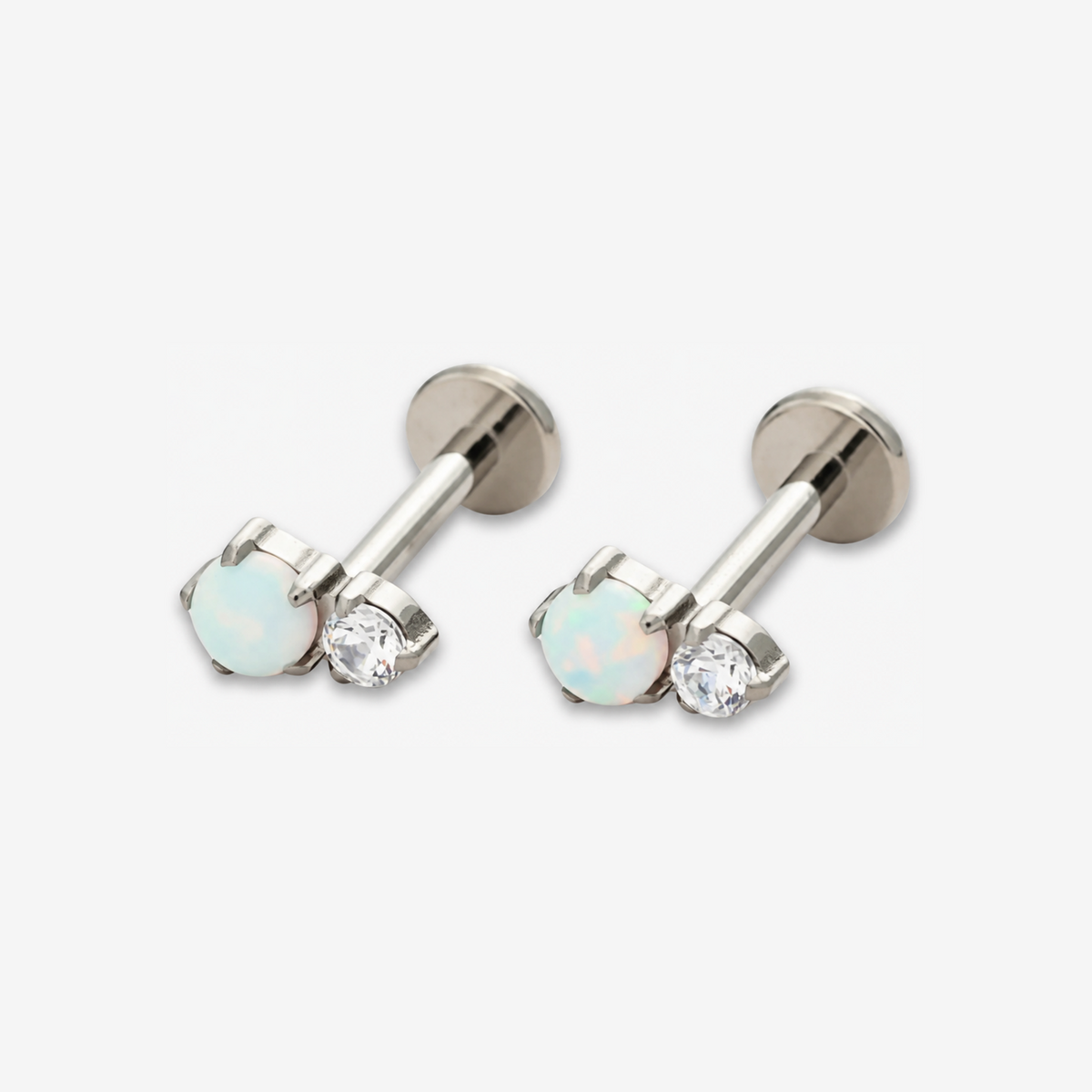 Twin Moonlight titanium flat back earrings with a white opal and clear stone.